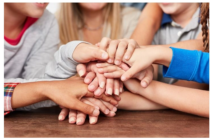 Mehrere Kinder legen ihre Hände gemeinsam übereinander.&nbsp;&copy;&nbsp;Canva